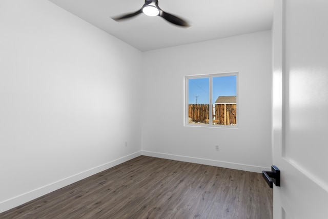 empty room with baseboards, dark wood-style floors, and ceiling fan