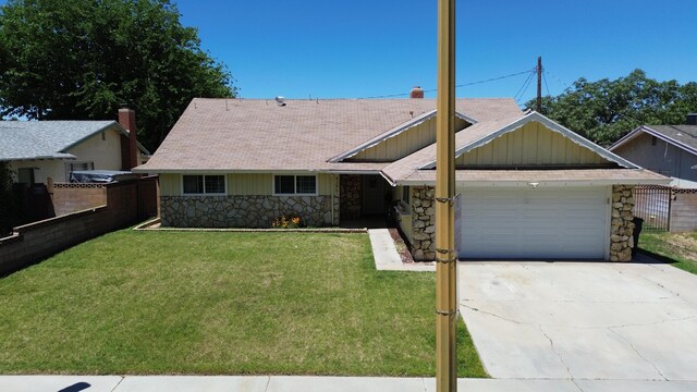 43861 W Elm Ave, Lancaster, CA 93534 - view of front of house featuring stone siding, a garage, concrete driveway, board and batten siding, and roof with shingles