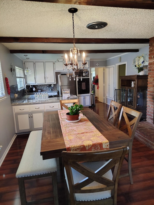 43861 W Elm Ave, Lancaster, CA 93534 - dining area featuring a chandelier, dark wood finished floors, beamed ceiling, a textured ceiling, and baseboards