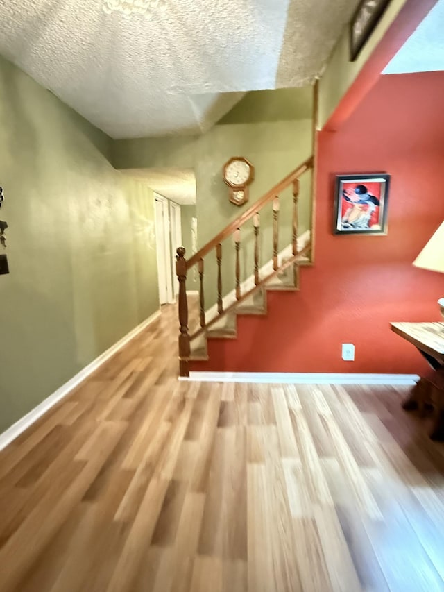 43861 W Elm Ave, Lancaster, CA 93534 - stairway with wood finished floors, a textured ceiling, and baseboards