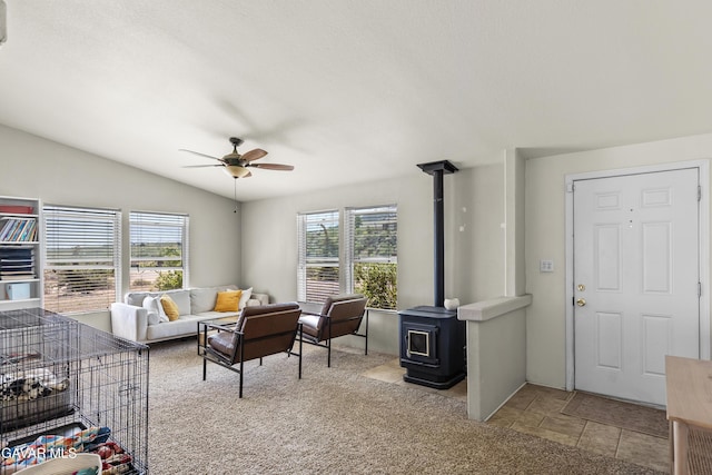 18909 Cheyenne Ave, Tehachapi, CA 93561 - living room featuring a wood stove, a ceiling fan, vaulted ceiling, and stone finish flooring