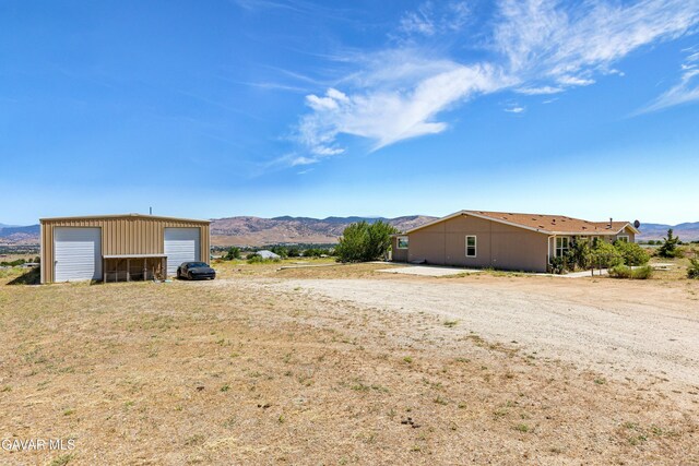 18909 Cheyenne Ave, Tehachapi, CA 93561 - view of yard featuring a mountain view, a detached garage, and an outdoor structure