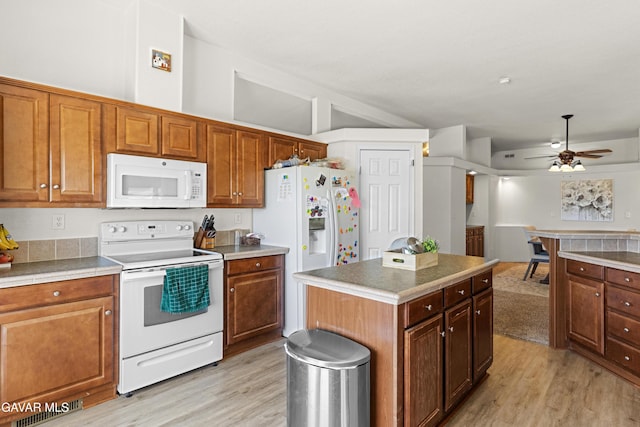 18909 Cheyenne Ave, Tehachapi, CA 93561 - kitchen with white appliances, light wood-type flooring, ceiling fan, and brown cabinetry