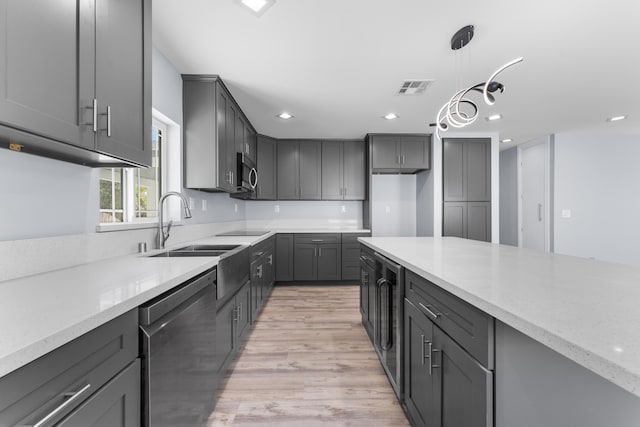 kitchen featuring gray cabinets, light stone counters, pendant lighting, and stainless steel appliances