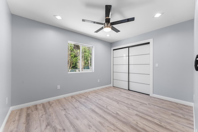 unfurnished bedroom with a closet, light hardwood / wood-style floors, and ceiling fan