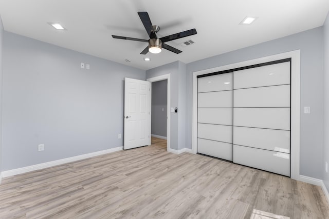 unfurnished bedroom with ceiling fan, light wood-type flooring, and a closet