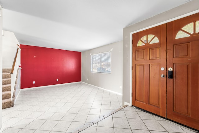 entrance foyer with light tile patterned flooring, baseboards, and stairs