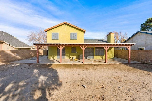 rear view of house with a patio and a fenced backyard