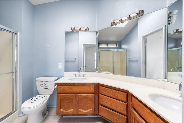 bathroom with a shower stall, double vanity, a sink, and tile patterned floors