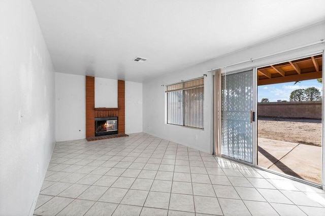 unfurnished living room featuring light tile patterned floors, a fireplace, and visible vents