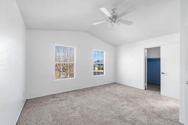 unfurnished room with carpet flooring, vaulted ceiling, and ceiling fan