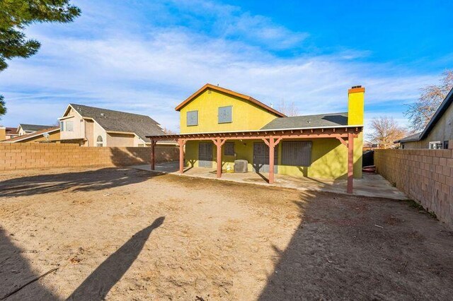 rear view of house featuring a fenced backyard, a patio, and a chimney