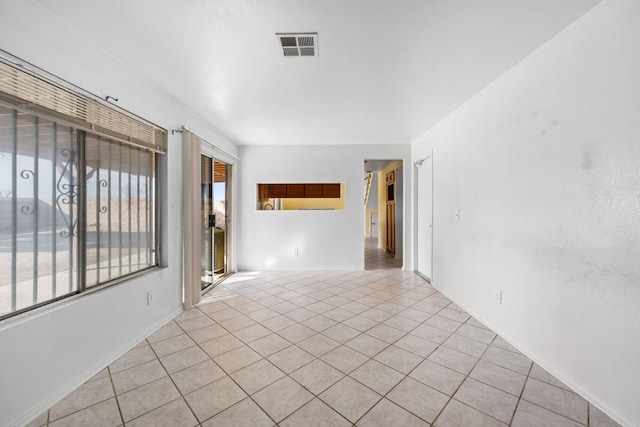 unfurnished room with visible vents, baseboards, and light tile patterned floors