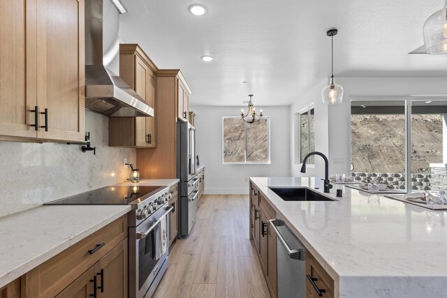 29181 Fawn Way, Tehachapi, CA 93561 - kitchen featuring high quality appliances, wall chimney exhaust hood, a sink, light wood-style flooring, and light stone counters