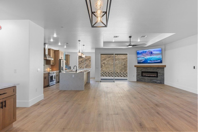29181 Fawn Way, Tehachapi, CA 93561 - unfurnished living room with a raised ceiling, a stone fireplace, baseboards, and light wood finished floors
