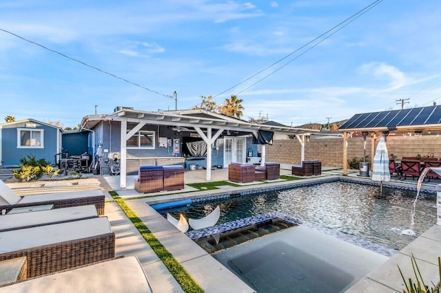 back of property with an outdoor living space, a pool with hot tub, and a patio area