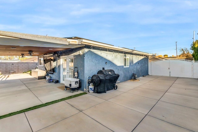 view of side of property with ceiling fan and a patio area