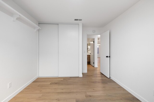 2203 Scott Ave, Palmdale, CA 93550 - unfurnished bedroom featuring light wood-type flooring, a closet, visible vents, and baseboards
