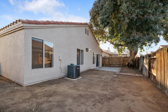 2203 Scott Ave, Palmdale, CA 93550 - back of house with a fenced backyard, a tile roof, central air condition unit, a patio area, and stucco siding