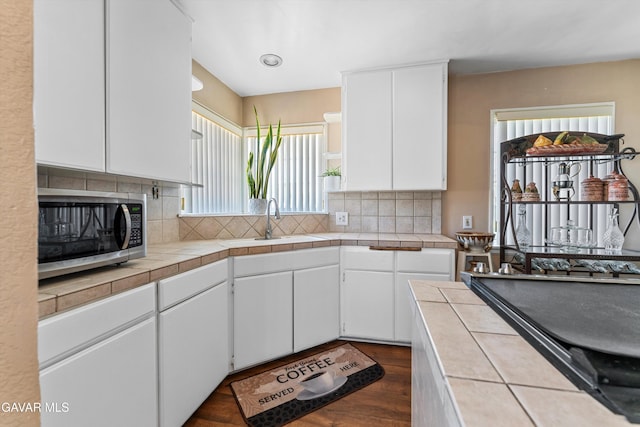 44344 Elm Ave, Lancaster, CA 93534 - kitchen featuring stainless steel microwave, tile counters, and white cabinets