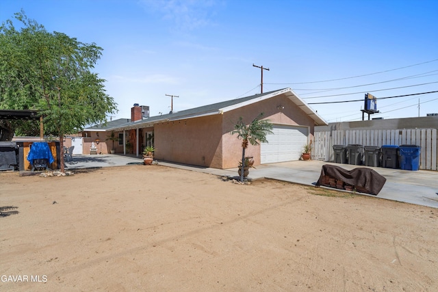 44344 Elm Ave, Lancaster, CA 93534 - back of property with driveway, stucco siding, and a chimney