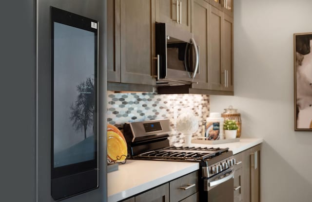 kitchen featuring tasteful backsplash, appliances with stainless steel finishes, light countertops, and gray cabinetry