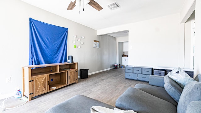 living room with ceiling fan, light wood finished floors, and baseboards
