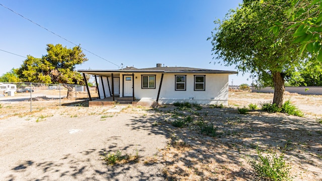 view of front facade featuring covered porch, fence, and stucco siding