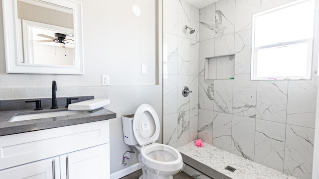 bathroom with vanity, a marble finish shower, toilet, and ceiling fan