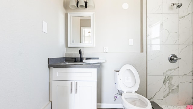bathroom featuring vanity, a marble finish shower, and toilet