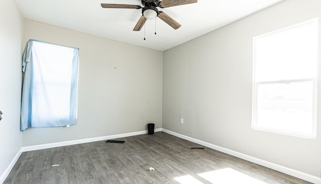 empty room featuring wood finished floors, baseboards, and a ceiling fan
