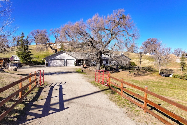 view of front facade featuring a rural view, a garage, and a front yard