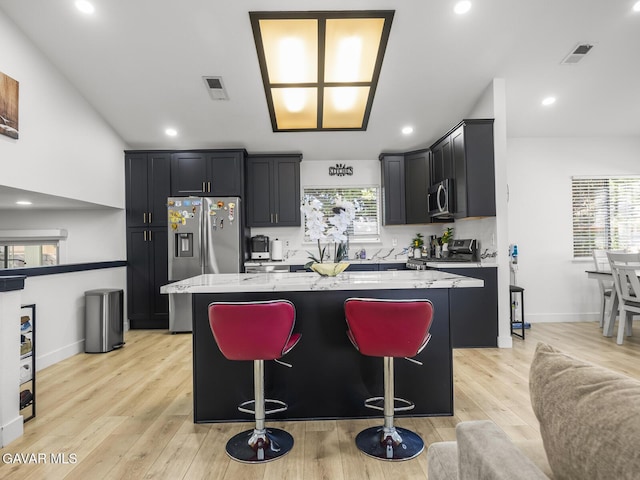 1324 Windermere Ct, Palmdale, CA 93551 - kitchen featuring appliances with stainless steel finishes, a center island, light stone countertops, light wood-style flooring, and recessed lighting