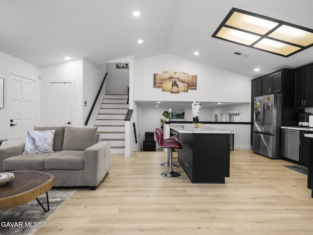 1324 Windermere Ct, Palmdale, CA 93551 - kitchen with stainless steel appliances, vaulted ceiling, dark cabinetry, a kitchen island, and open floor plan