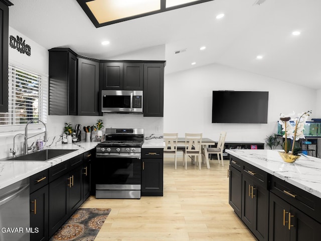 1324 Windermere Ct, Palmdale, CA 93551 - kitchen with stainless steel appliances, lofted ceiling, dark cabinets, light wood-type flooring, and recessed lighting