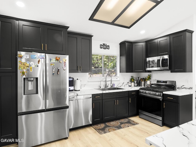 1324 Windermere Ct, Palmdale, CA 93551 - kitchen featuring stainless steel appliances, dark cabinets, light stone counters, light wood finished floors, and recessed lighting