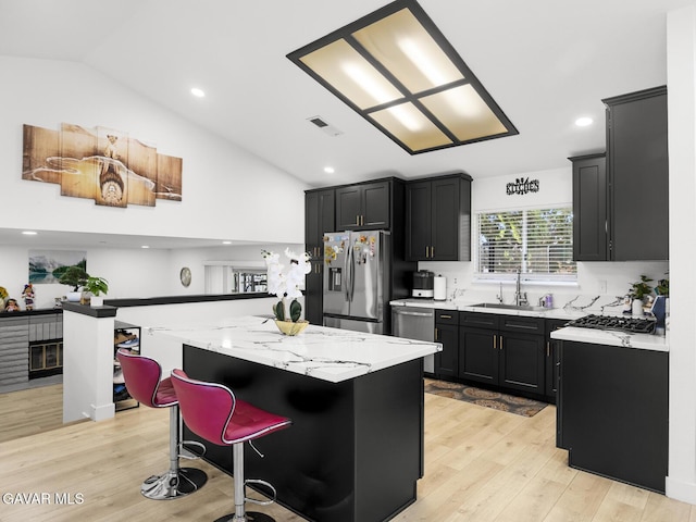 1324 Windermere Ct, Palmdale, CA 93551 - kitchen featuring stainless steel appliances, dark cabinets, a kitchen island, light wood-style floors, and recessed lighting