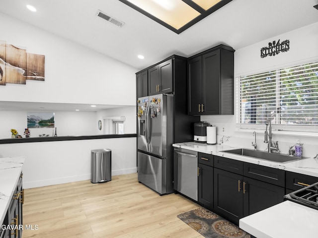 1324 Windermere Ct, Palmdale, CA 93551 - kitchen with appliances with stainless steel finishes, light wood finished floors, dark cabinetry, light countertops, and lofted ceiling