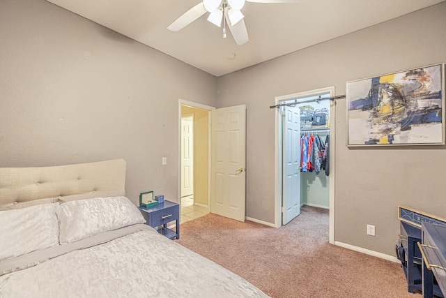 carpeted bedroom featuring a spacious closet, baseboards, a closet, and ceiling fan