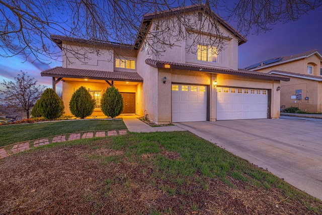 view of front of property with stucco siding, a front lawn, driveway, a tile roof, and an attached garage