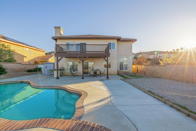 rear view of house with a patio area, stucco siding, a fenced backyard, and a chimney