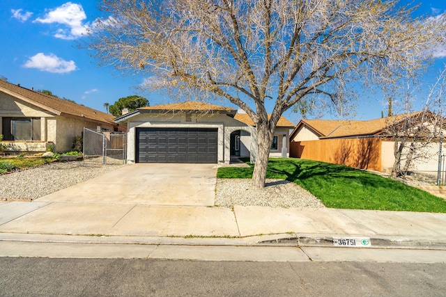 view of front facade with driveway, stucco siding, an attached garage, fence, and a front yard