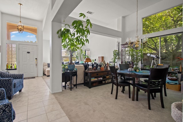 dining space with a high ceiling, light tile patterned floors, and an inviting chandelier