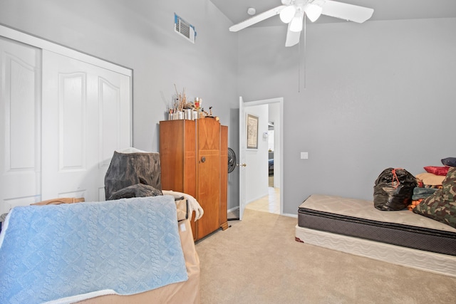 bedroom featuring ceiling fan, a closet, high vaulted ceiling, and light carpet