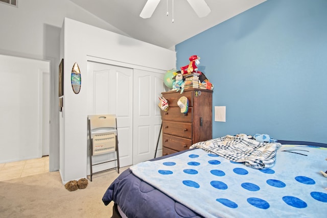 carpeted bedroom with ceiling fan, lofted ceiling, and a closet