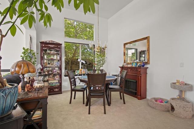 carpeted dining space with a high ceiling and an inviting chandelier