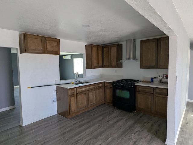 kitchen with black range with gas stovetop, wall chimney exhaust hood, a sink, and dark wood-style flooring