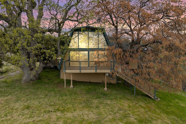 rear view of house with stairway, a deck, and a yard