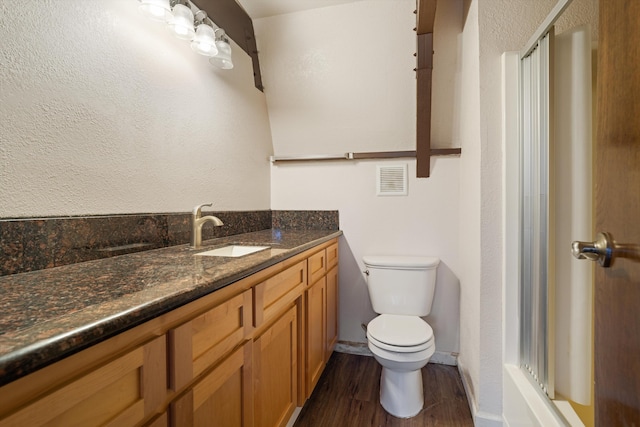 full bath featuring vanity, toilet, wood finished floors, visible vents, and a stall shower