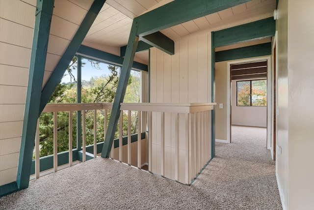 hallway featuring carpet floors and beam ceiling